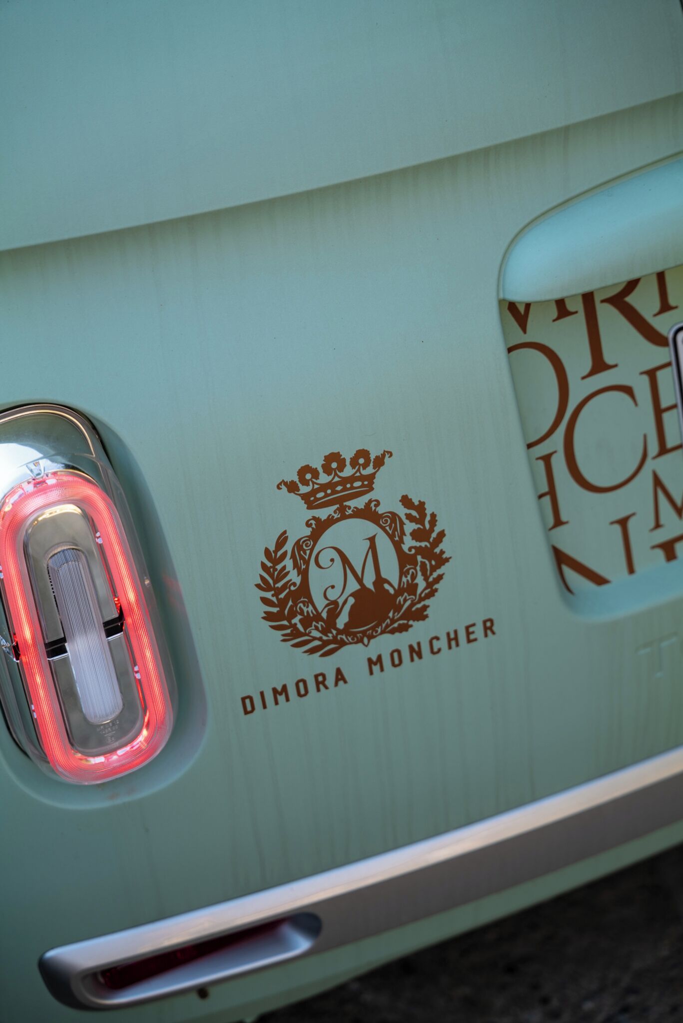 A vehicle's rear with a logo and text reading "DIMORA MONCHER."