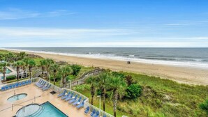 A beach view with a pool area and lounge chairs. - Crescent Shores 309- Oceanfront 2 BBR- Pool (North Myrtle Beach)