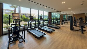 Een sportschool met loopbanden, elliptische trainers en losse gewichten.