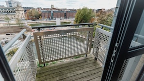 En balkon med udsigt til en flod, bygninger og en bro.