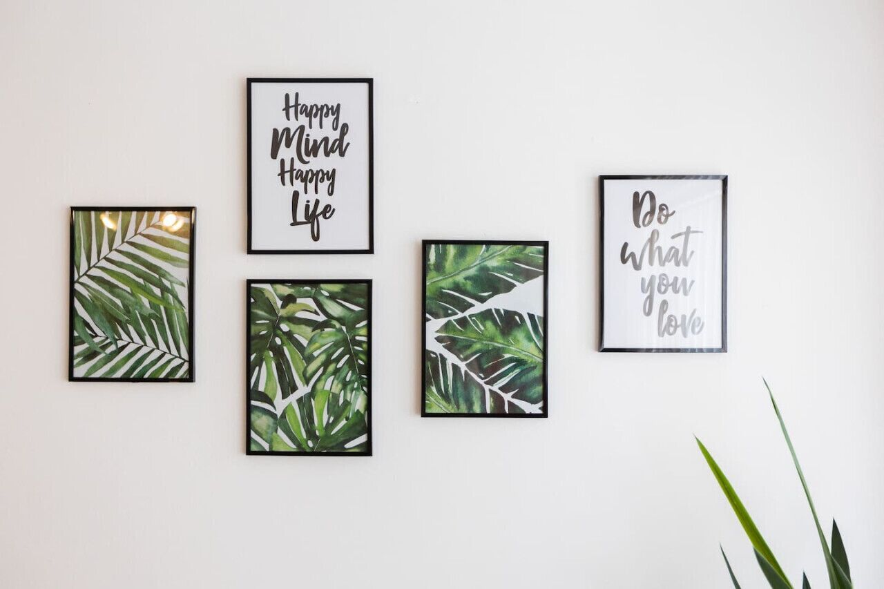 Four framed leaf prints on a wall.