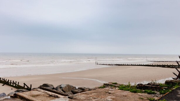 A beach with a wooden jetty extending into the sea, a rocky foreground, and a cloudy sky. - Hullidays》Withernsea Duplex Apt (Withernsea)