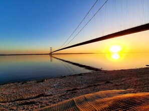Un pont penjat sobre un cos d'aigua tranquil durant el capvespre.
