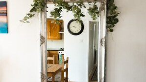 A mirror with an ornate frame, a wooden dining table, and a clock on the wall. - Hullidays》Victoria Dock Residence (Kingston upon Hull)