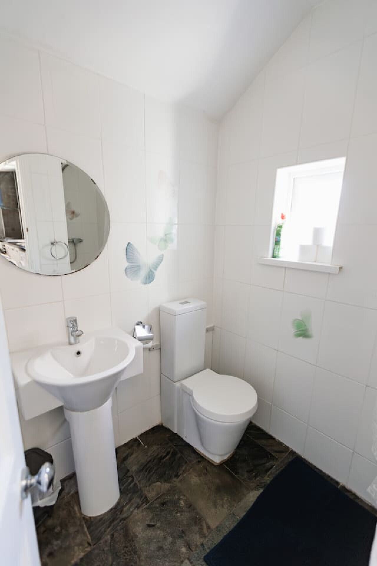 A bathroom with a white sink, toilet, and mirror.