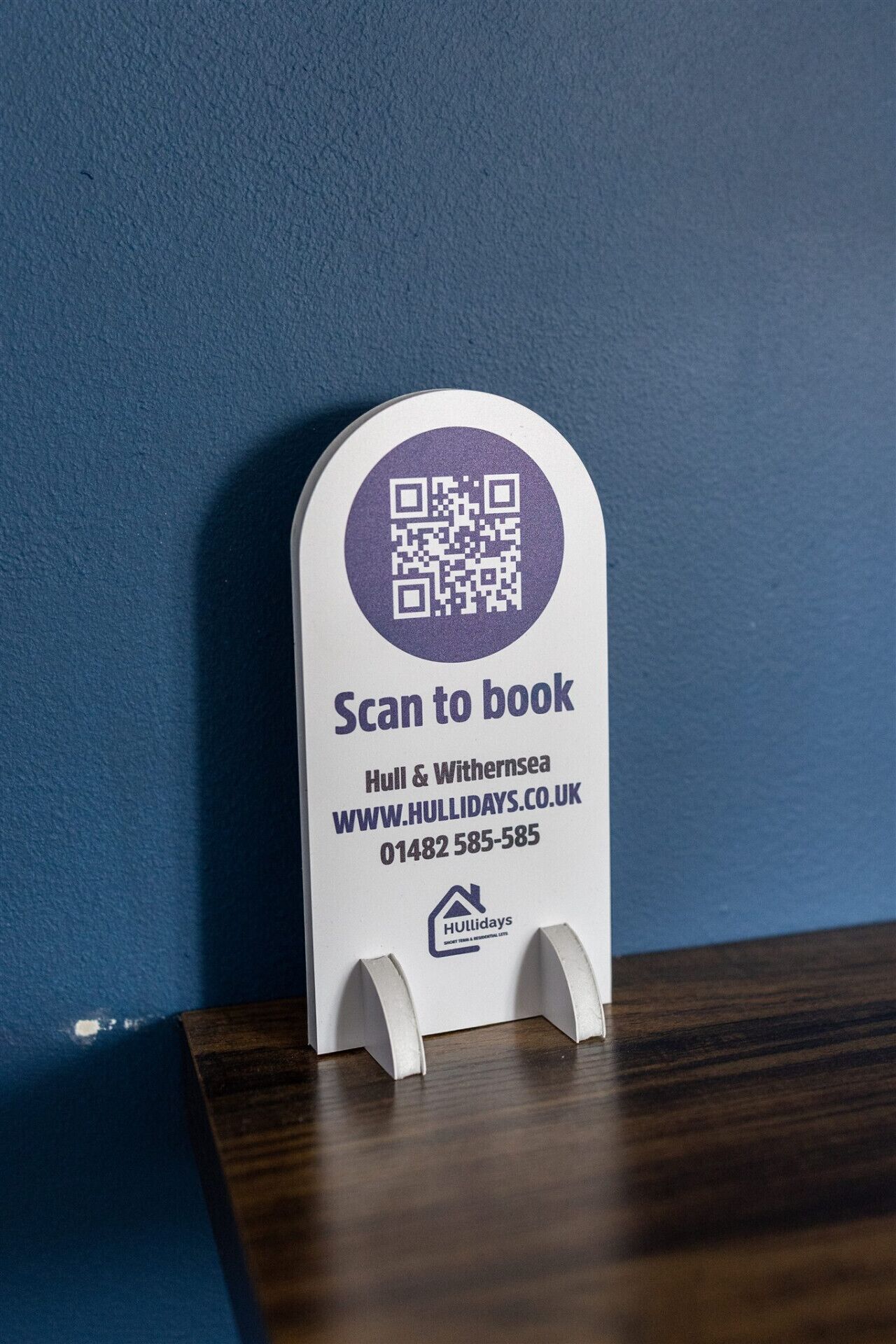 Een QR-code standaard met een 'Scannen om te boeken' instructie, een website-URL en een telefoonnummer voor Hull & Withernsea.