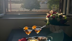 Een tafel met drankjes en desserts bij een raam met uitzicht op bergen.