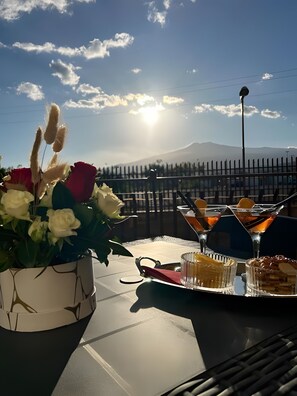 Et bord med blomster, glas og en bakke med mad.