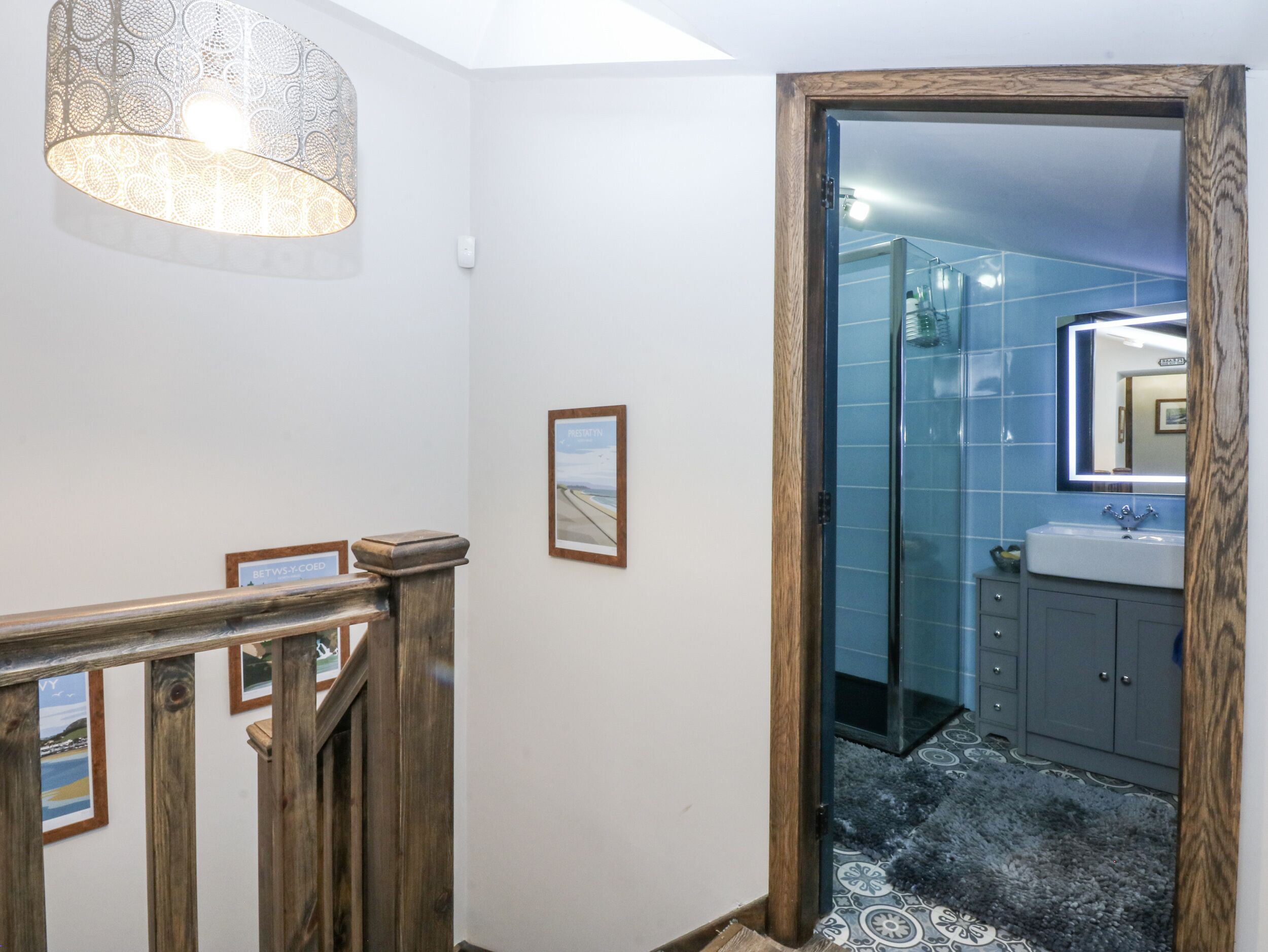 A bathroom with a glass shower enclosure, a sink, and a mirror.