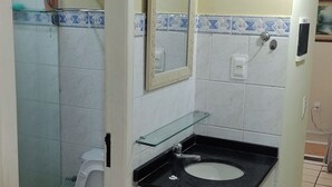 Un bagno compatto con servizi igienici, lavabo e specchio.