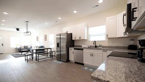 A modern kitchen with white cabinets, granite countertops, and stainless steel appliances. - 4 Min to Downtown | 10 to Elon | Car Rental Avail. (Burlington)