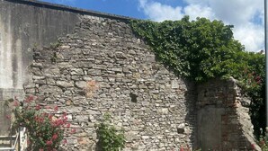 A stone wall with a metal railing in the foreground. - The Courtyard Retreat (Sligo)