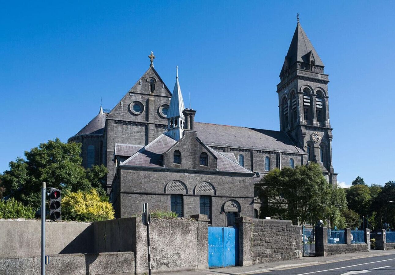 A historic building with a prominent clock tower and a large church entrance.