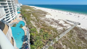 Un resort con una gran piscina, acceso a la playa y vistas al océano.