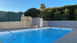 A rectangular swimming pool with a metal ladder, surrounded by a tiled deck. - Renovated Provencal villa 50 m from the sea Résidence Hélios (Saint Raphael)