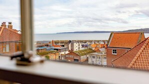 A coastal town with red-tiled buildings, a marina, and a view of the sea. - Harbour View House | Old Town, Sea Views | Sleeps 8 (North Yorkshire)