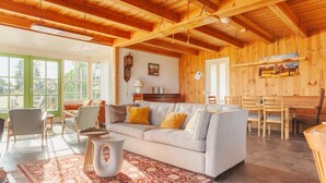 A cozy living room with a sofa, chairs, a dining table, and a rug. - 20P 6B Beautiful house in Nature (Scheerwolde)