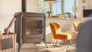 A cozy room with a wood-burning stove, wicker basket, and yellow chairs. - 20P 6B Beautiful house in Nature (Scheerwolde)