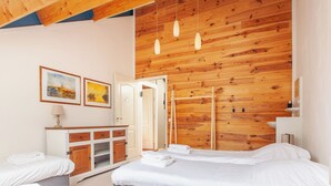 A modern hotel room with wooden ceiling beams, a wooden wardrobe, two beds with white linens, and two framed paintings on the wall. - 20P 6B Beautiful house in Nature (Scheerwolde)