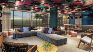 A modern lounge area with sectional sofas, a round coffee table, and a bar area with stools. - Modern and Fully Equipped Accommodations Near the Metro and Praca da Republica - Dnrs (São Paulo)
