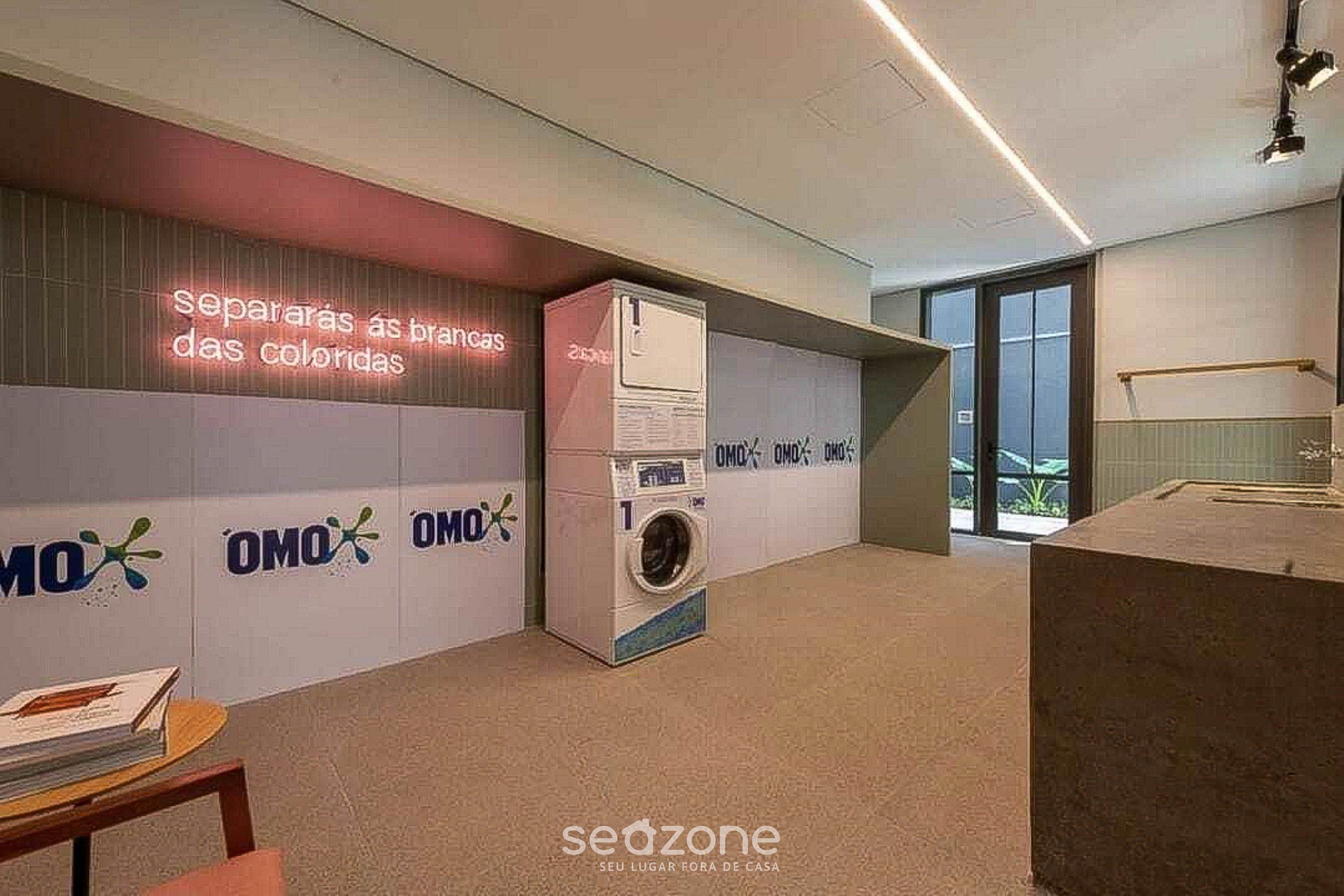 Un intérieur moderne avec un lave-linge, un néon et un logo répété sur le mur.