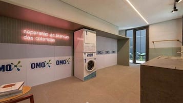 Um interior moderno com máquina de lavar, luminária neon e um logotipo repetido na parede.