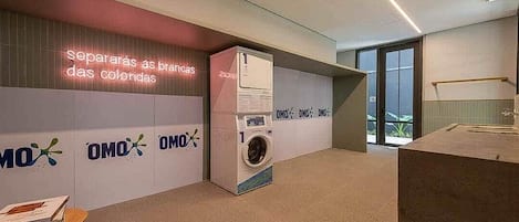 A modern interior with a washing machine, a neon sign, and a logo repeated on the wall.