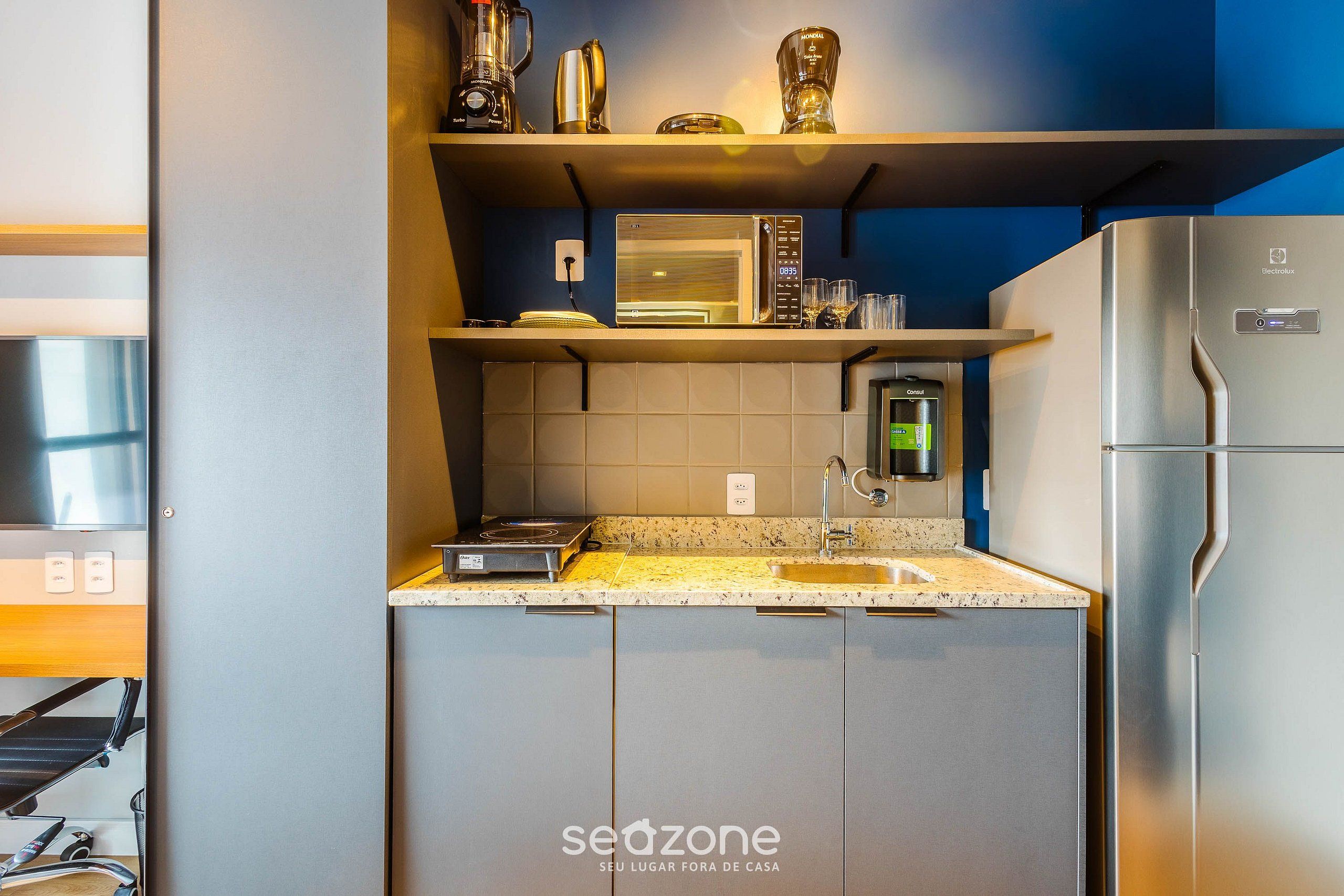 A compact kitchen with a microwave, toaster, and refrigerator.