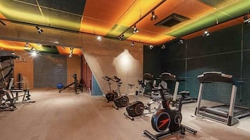 Uma academia com diversos equipamentos de exercício, incluindo esteiras, bicicletas ergométricas e aparelhos de musculação.
