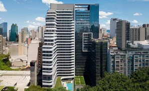 Un immeuble de grande hauteur doté d’une architecture moderne, caractérisé par une façade incurvée et de nombreux balcons.