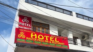 A hotel with a prominent red sign advertising 'Master Price Inn & Restaurant'. - Staylo Masterprice Inn (Lucknow)