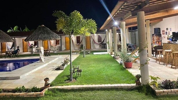 A courtyard with a swimming pool, outdoor seating, and a bar area.