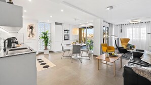 A modern apartment with a kitchen, dining area, and living room.