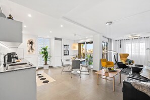 A modern apartment with a kitchen, dining area, and living room.