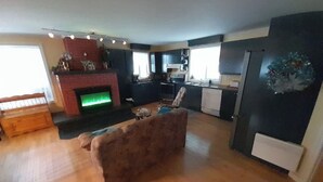 A modern kitchen with dark cabinetry, a built-in oven, and a microwave.