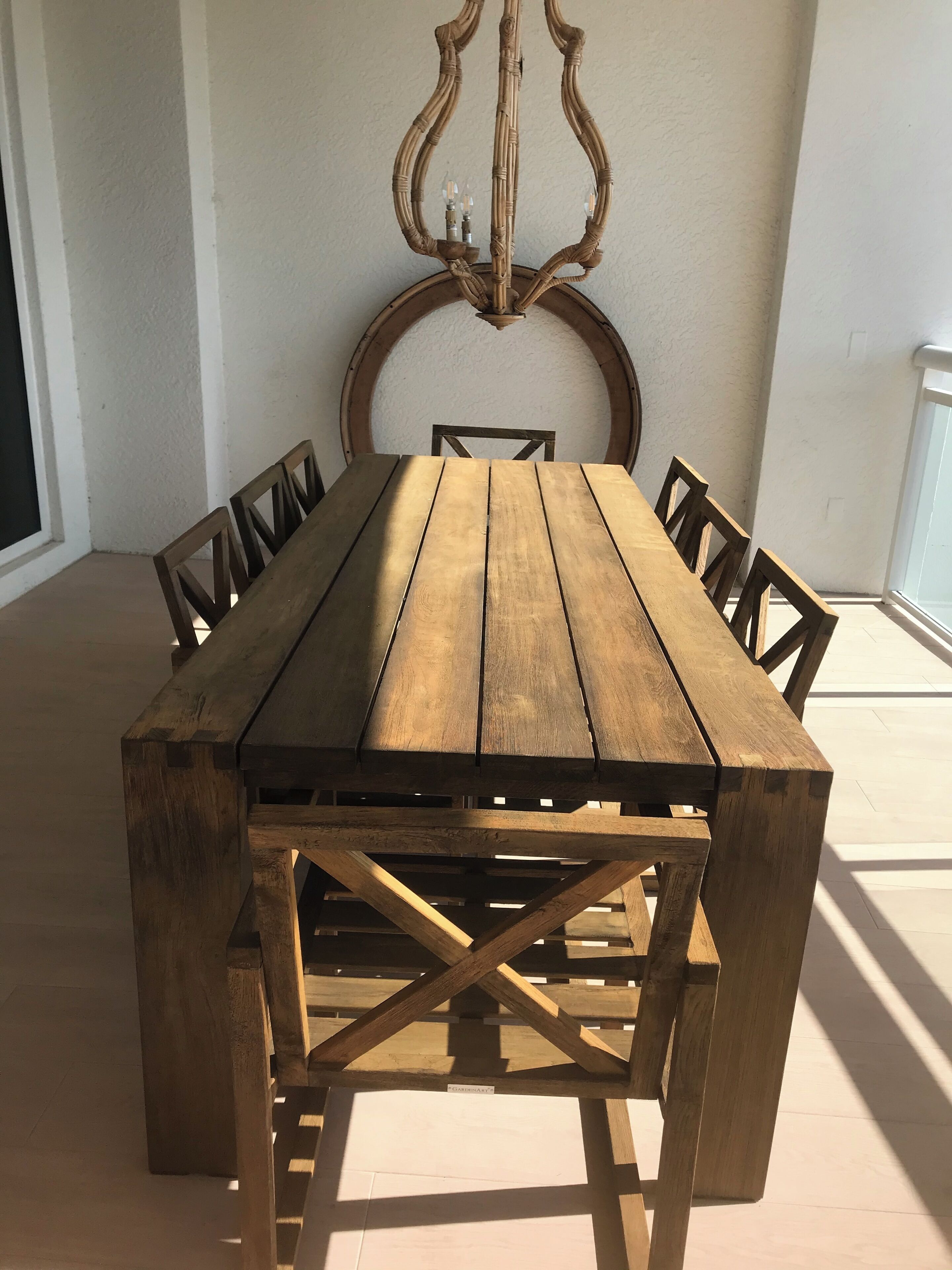 Ein Holzespeisezimmer mit Stühlen, einem Zier-Spiegel und einer Lampe.