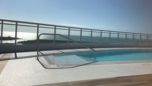 Ein Pool auf dem Dach mit freiem Blick auf den Ozean.
