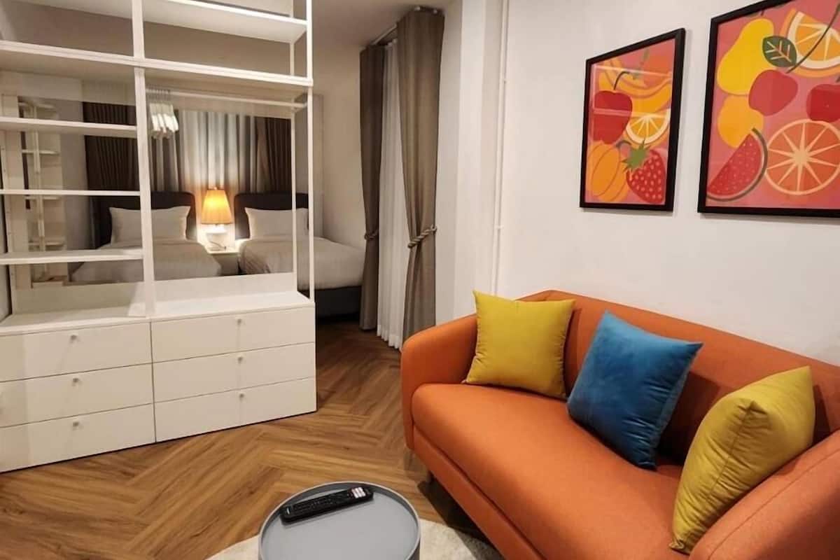 A modern living room with a sofa, a small round table, and a white storage unit with drawers.