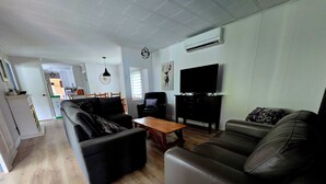 Una sala de estar moderna con un conjunto de sofá, una mesa de centro y un televisor.