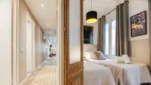 A hotel room with two beds, a hallway, and a large window. - Boutique Living in the Heart of Barcelona (Barcelona)