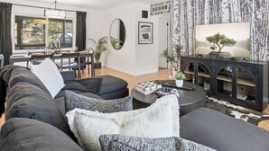 A modern living room with a sofa set, a coffee table, and a TV on a stand.
