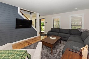 Una Smart TV, una chimenea, una pantalla de ordenador, una impresora