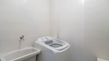 Un baño pequeño y blanco con inodoro, lavamanos y ducha.