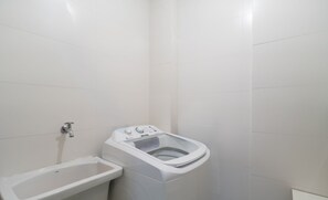 A small, white bathroom with a toilet, a sink, and a shower. - Apartments 110 m From the Beach in Floripa - AGC (Florianópolis)