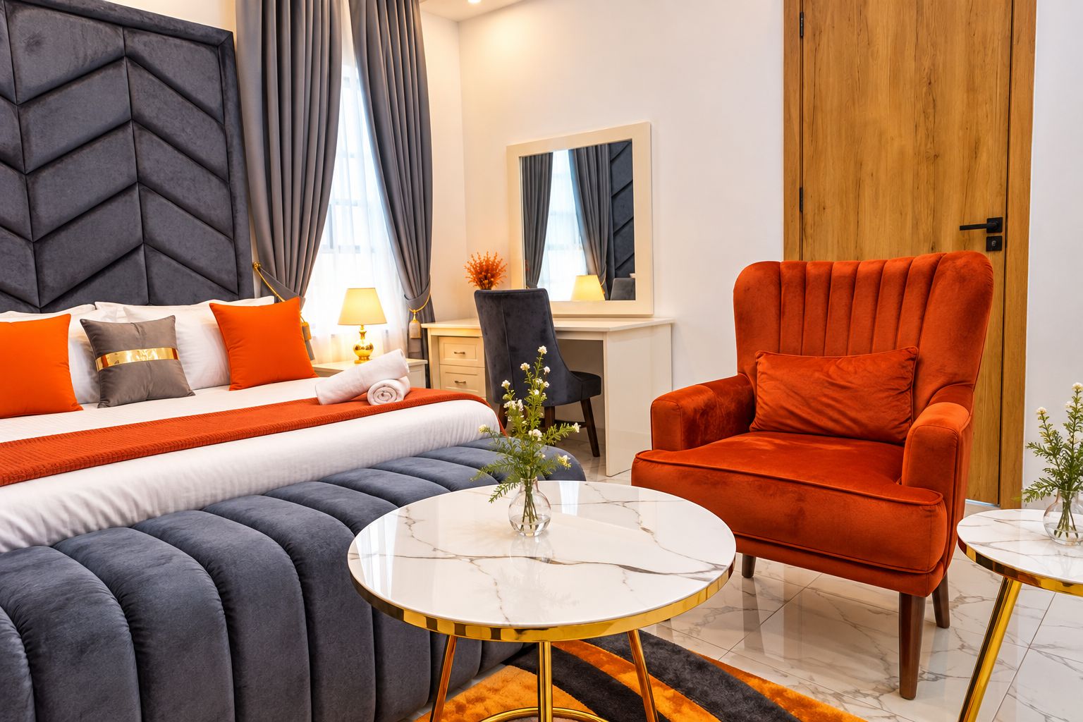 A modern hotel room with a bed, a desk, a chair, and a round table.