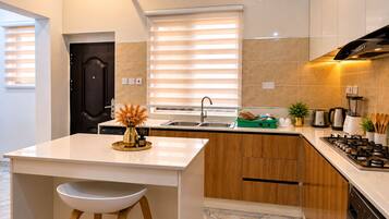 A modern kitchen with a central island, a built-in oven, and a gas stove.