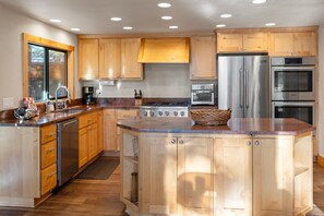 A modern kitchen with wooden cabinets, stainless steel appliances, and a central island.