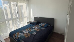 Une chambre à coucher avec un lit, un bureau et une fenêtre.
