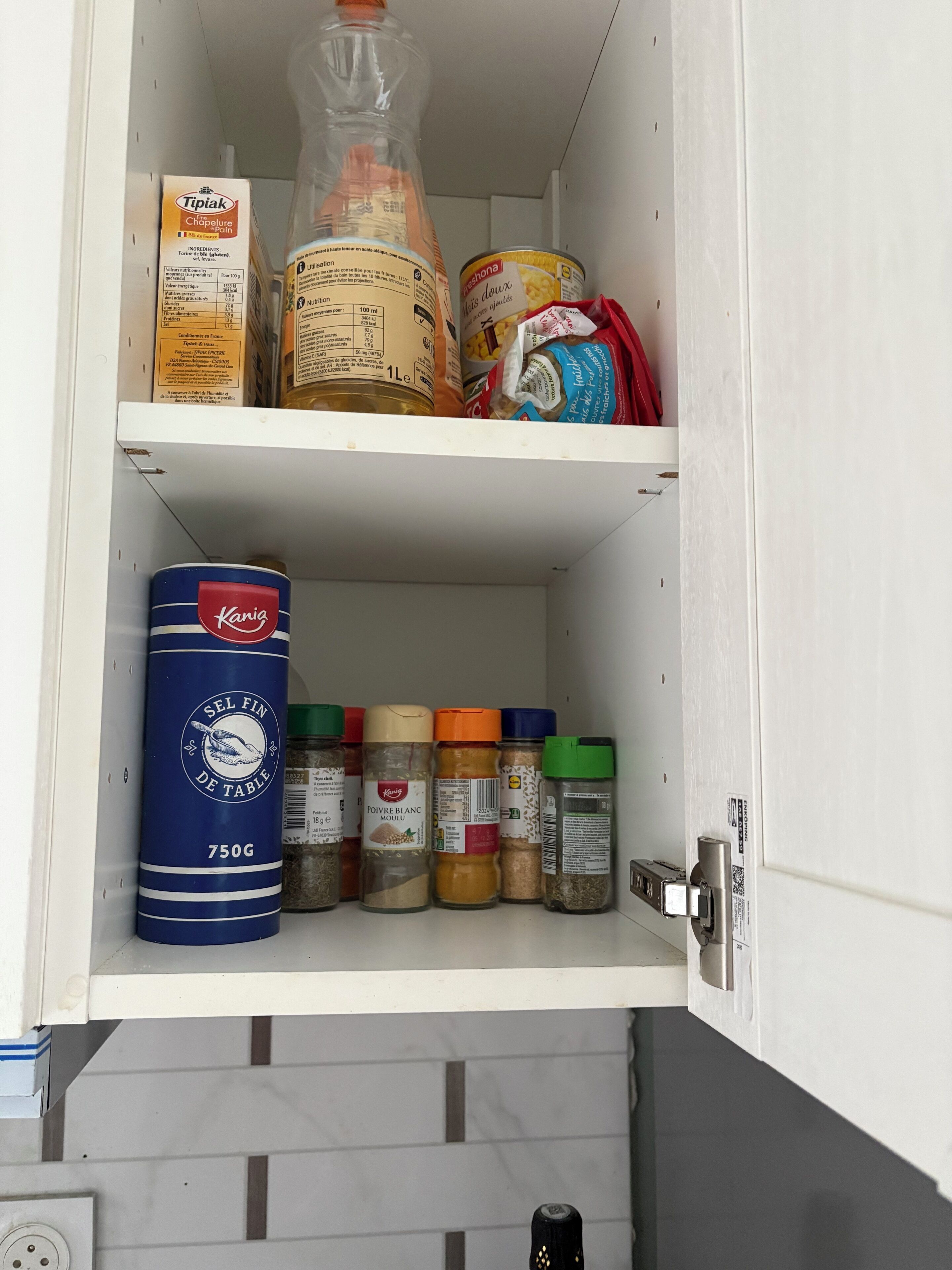 A kitchen pantry with various food items and spices.