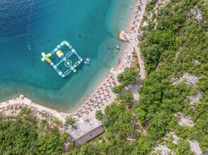 Playa en los alrededores, camastros, sombrillas y 2 bares en la playa 
